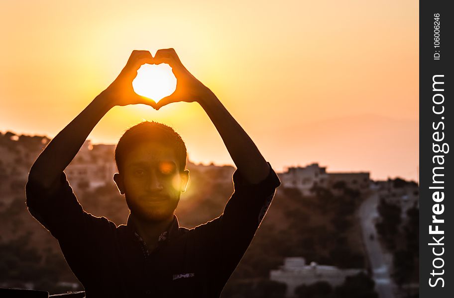 Person Making Heart Shape With His Hand During Sunset