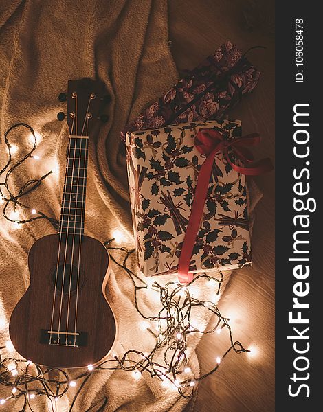 Ukulele Beside A Floral Box And String Lights