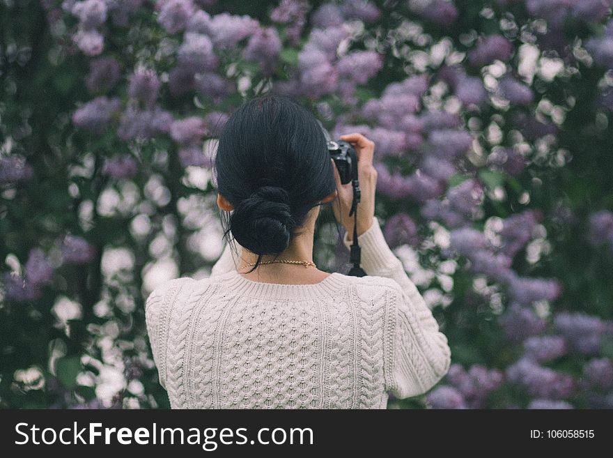 Woman Holding Camera Taking Photos Of Flowers