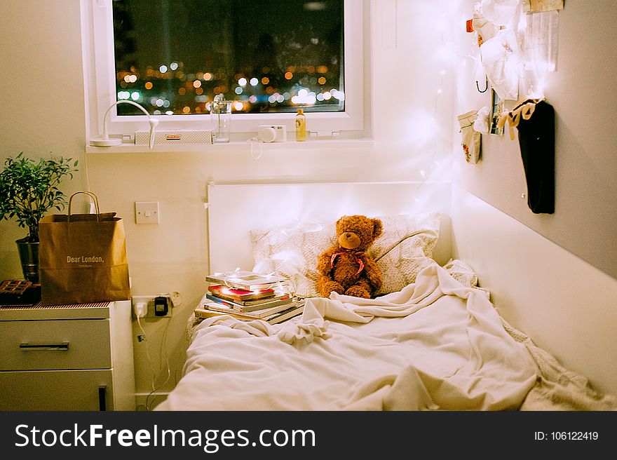 Brown Bear Plush Toy on White Bed Comforter Inside Lighted Bedroom