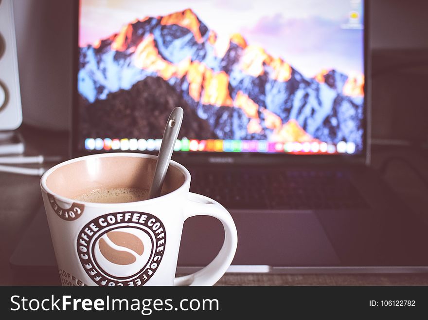 Photo of Cup of Coffee in Front of the Laptop
