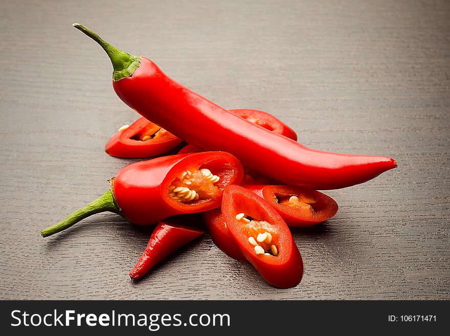 Bunch fresh raw red hot chilli pepper on a wooden background tied with a rope