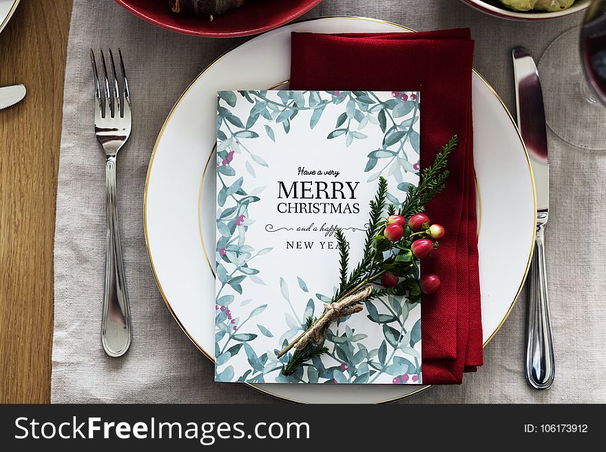 Merry Christmas Card On Plate Between Fork And Knife