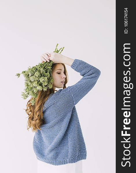 Woman In Blue Knit Cable Sweater Holding Green Petaled Flowers