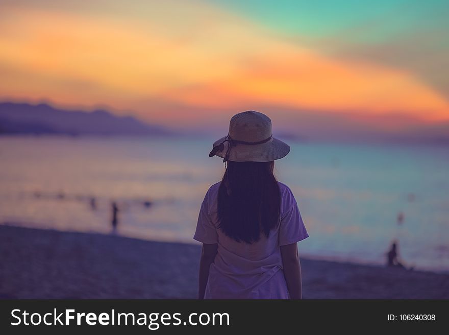 Woman in White Dress Standing Near Beach during Sunset