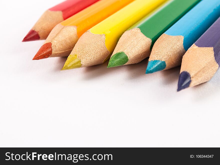 Wooden colored pencils on white background with free space