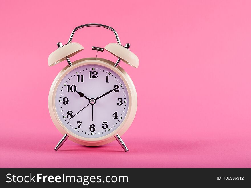 Old clock with alarm isolated on pink background with space for text