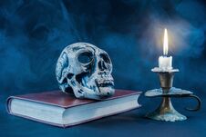 Gothic Skull On Old Book And Candle In Candlestick On Dark And Smoked Background Royalty Free Stock Images Gothic Skull On Old Book And Candle In Candlestick On Dark And Smoked Background Royalty Free Stock Images