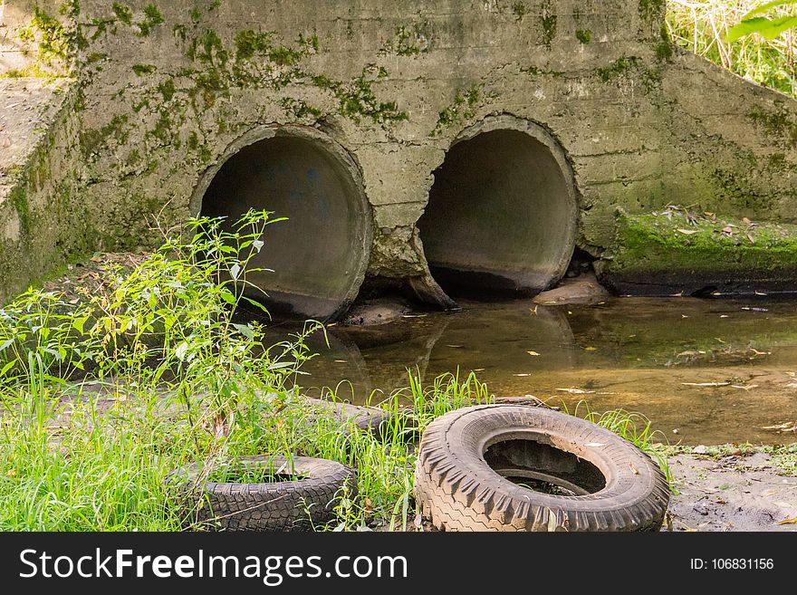 Large old concrete drain pipe, culvert in the grass. Large old concrete drain pipe, culvert in the grass.