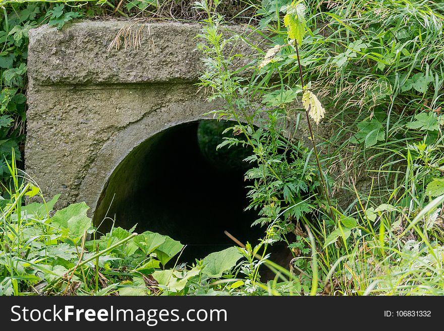 Large old concrete drain pipe, culvert in the grass. Large old concrete drain pipe, culvert in the grass.