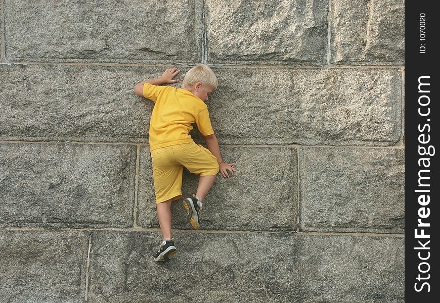 A little boy is climbing the base of Statue Of Liberty. A little boy is climbing the base of Statue Of Liberty