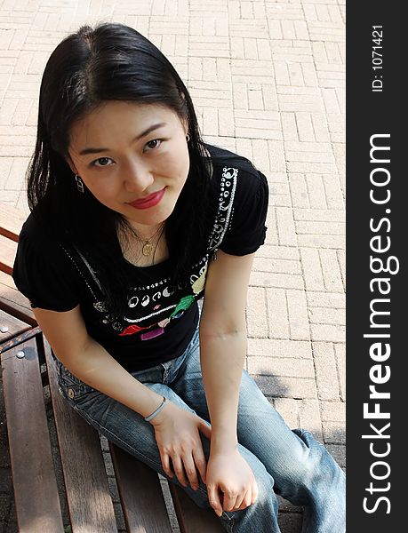 Portrait of a Korean woman sitting on a park bench