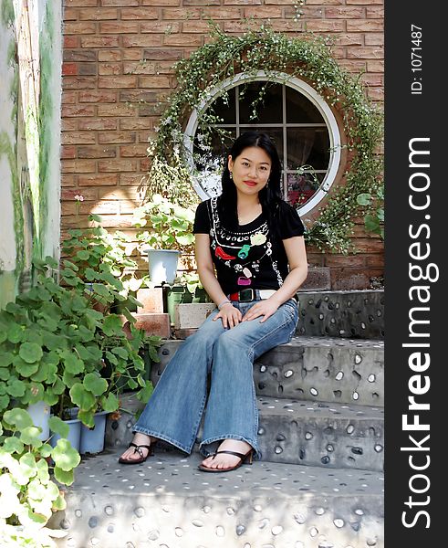 Portrait of a Korean woman sitting on steps in a garden. Portrait of a Korean woman sitting on steps in a garden
