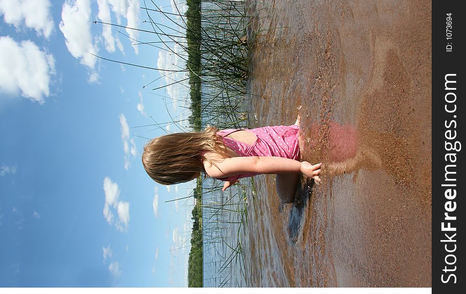 A little girl plays in the lake. A little girl plays in the lake