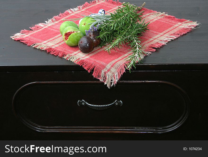 Setting with figs, rosemary and lavender on old chest of drawers. Setting with figs, rosemary and lavender on old chest of drawers