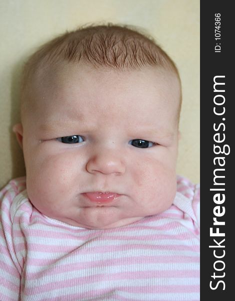 A portrait of a cute newborn baby with a serious face. A portrait of a cute newborn baby with a serious face.