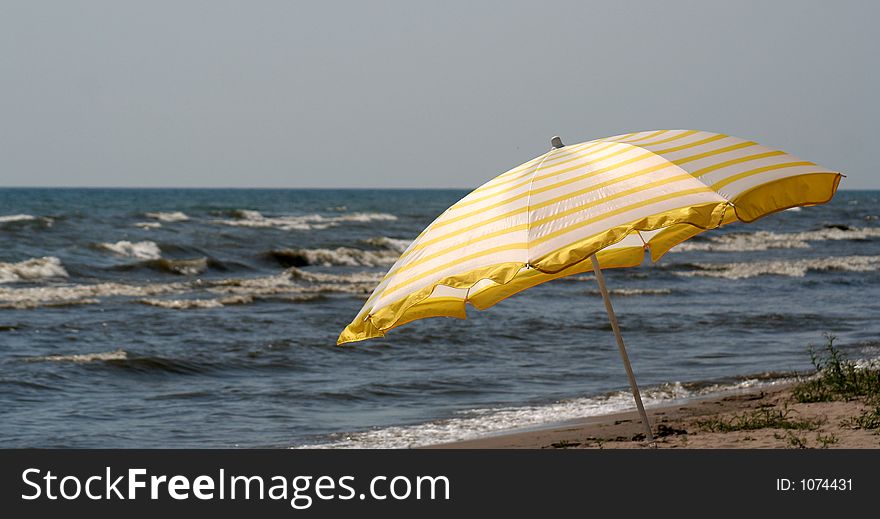 A beach umbrella set against the sea. A beach umbrella set against the sea.