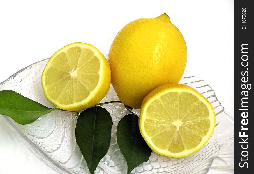 Half and whole lemon on crystal plate. Half and whole lemon on crystal plate