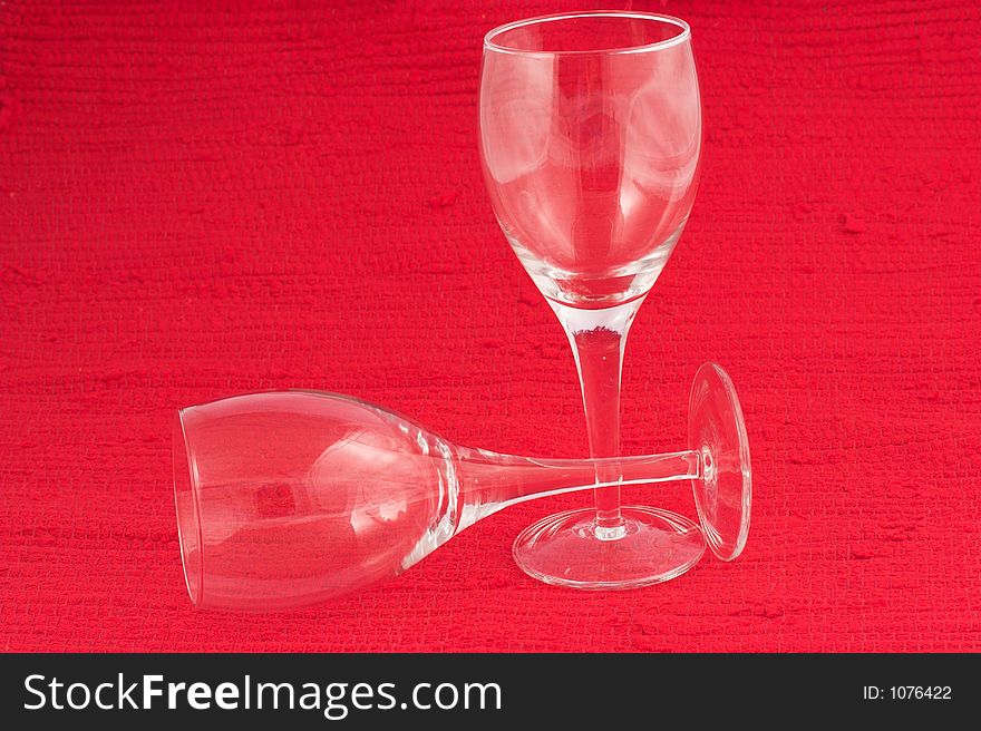 Two white wine glasses on red background