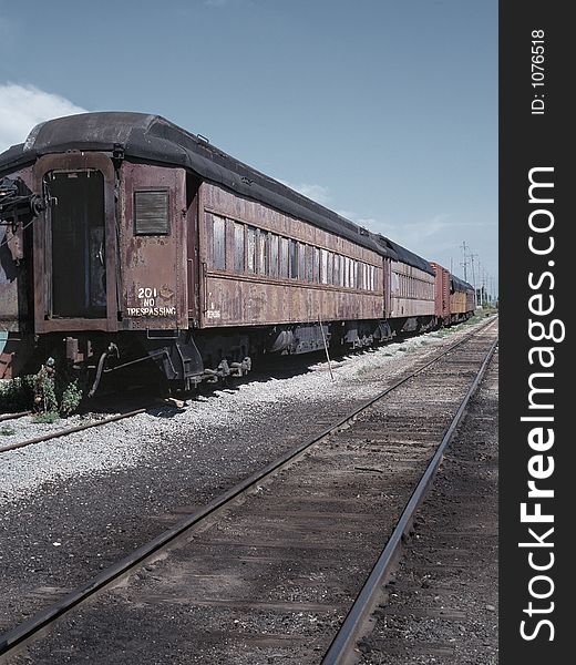 An old passenger train rotting away in a rail yard. An old passenger train rotting away in a rail yard.