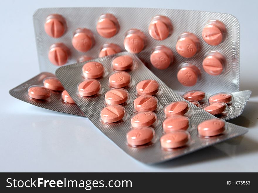 Pink pills isolated over white