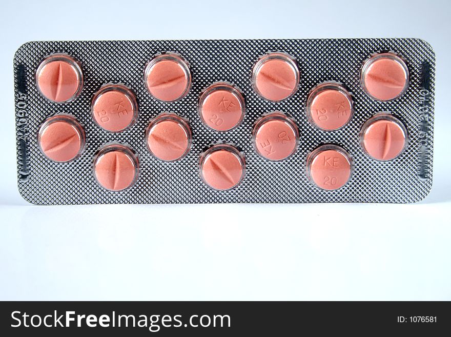 Pink pills isolated over white