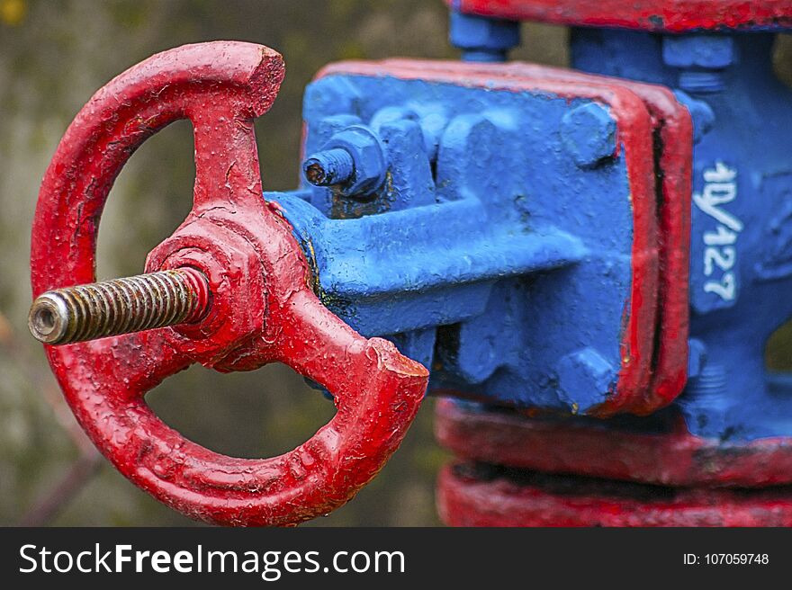 Steam pipe valve in red and blue colors with blurred background