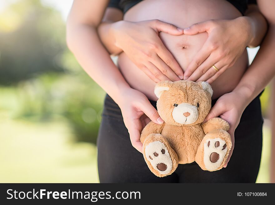 Pregnant woman with teddy bear