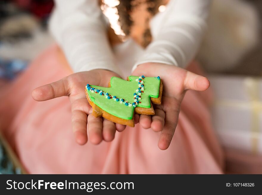 Girl holding a gingerbread Christmas tree . Holiday concept.