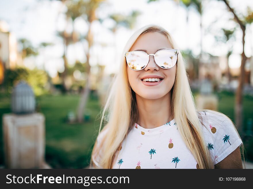 Close up portrait woman wearing sunglasses posing with palm tree