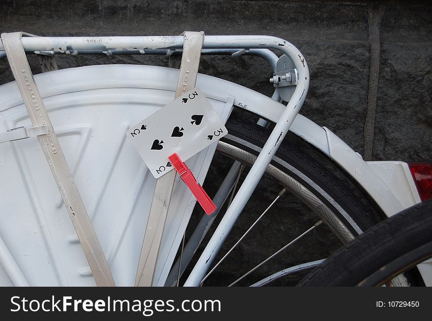 Playing card on a white wheel of fortune bike