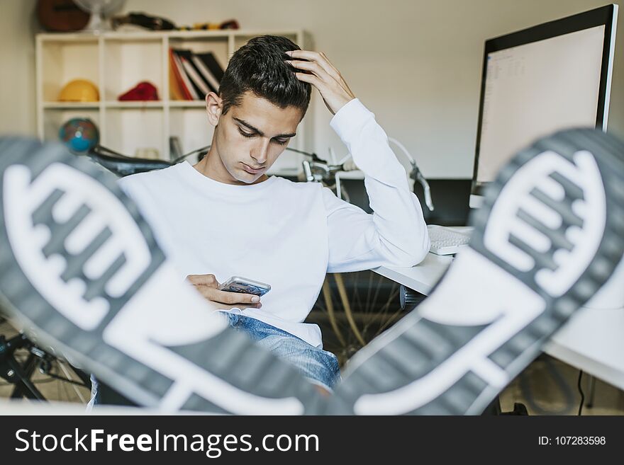 Young man smiling with the mobile phone at home