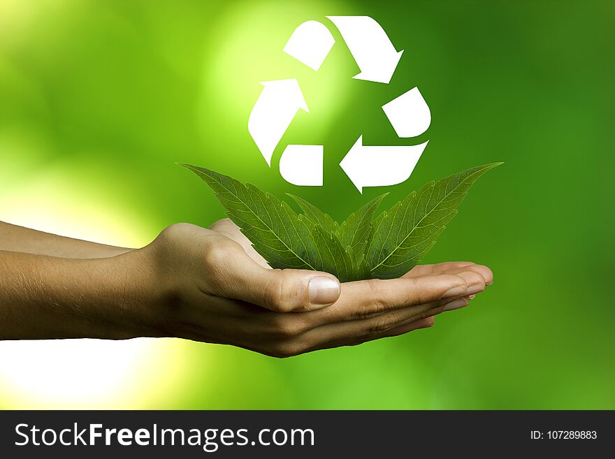 Hands with plants and recycling symbol