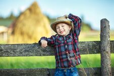 Little Boy Sits On Wooden Fence Against Picturesque Haystack Royalty Free Stock Photos