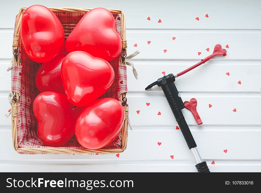 Red Valentine Hearts in wooden basket on a white wooden background, with writing space. Zenithal plane. Red Valentine Hearts in wooden basket on a white wooden background, with writing space. Zenithal plane.