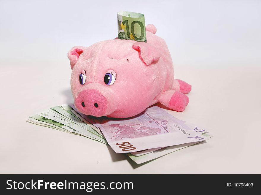 Pink soft piggy bank with 500 and 100 euro banknotes. Saving money. Pink soft piggy bank with 500 and 100 euro banknotes. Saving money