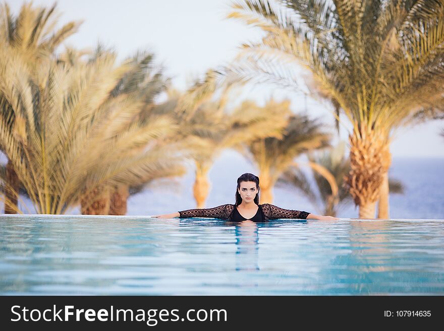 Portrait woman relax luxury pool villa, infinity sea view, she wear sun glasses, copy space. Portrait woman relax luxury pool villa, infinity sea view, she wear sun glasses, copy space.