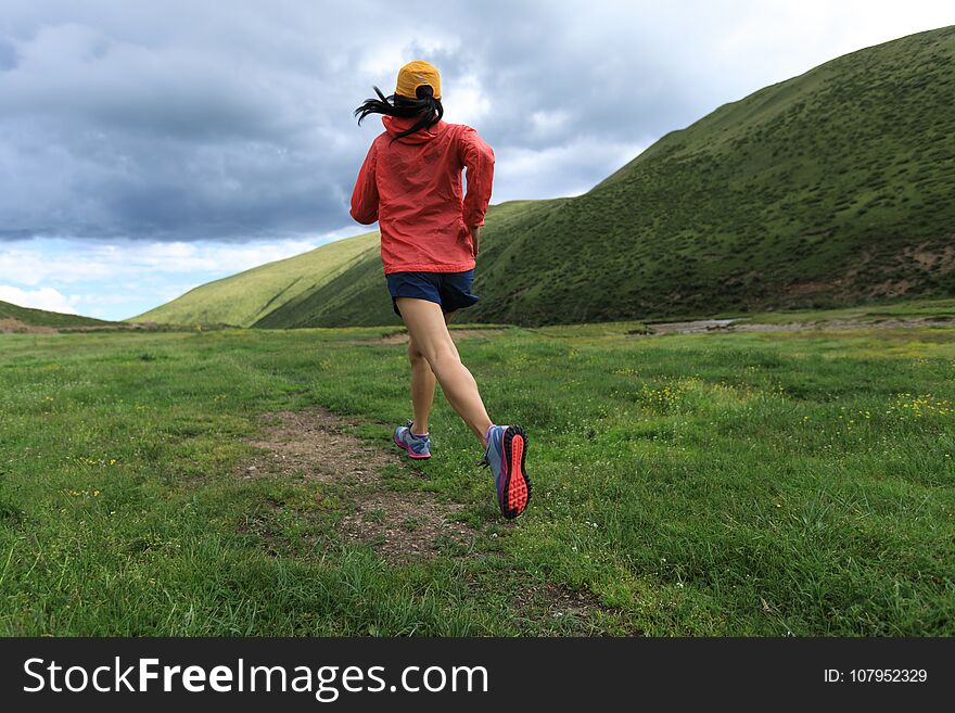 Young fitness woman trail runner running outside