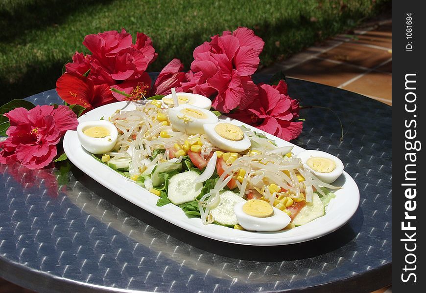 Fresh salad on a table whit flowers. Fresh salad on a table whit flowers