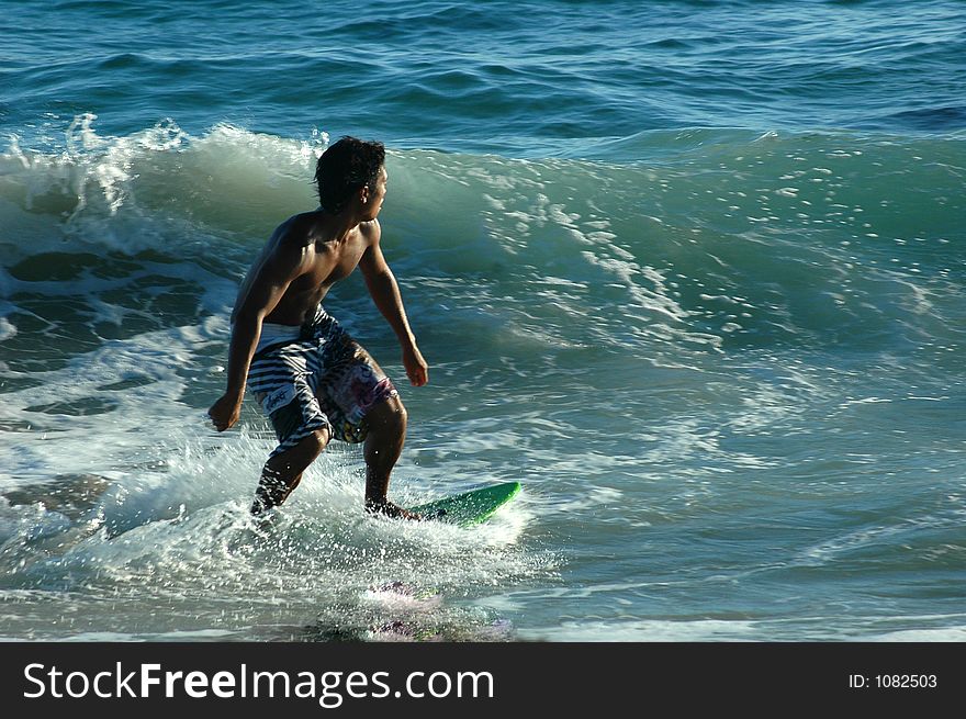 A guy in the skimboard in the ocean. A guy in the skimboard in the ocean