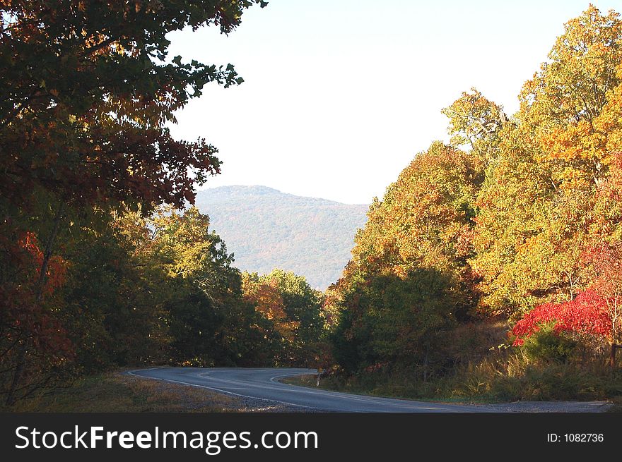 Acurved road with mountains and trees autumn colors. Acurved road with mountains and trees autumn colors.