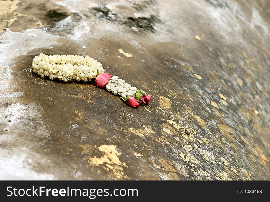 Gold pasted on Buddha body with a ring of flower. Offerred to Buddha in return of blessing
