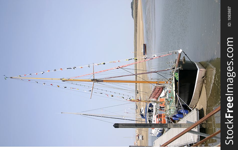 Tall boats sitting at the quayside at low tide. Tall boats sitting at the quayside at low tide