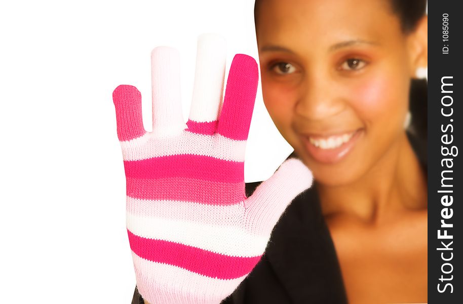 Black woman in dark suit smiling and looking at her pink winter glove. Black woman in dark suit smiling and looking at her pink winter glove