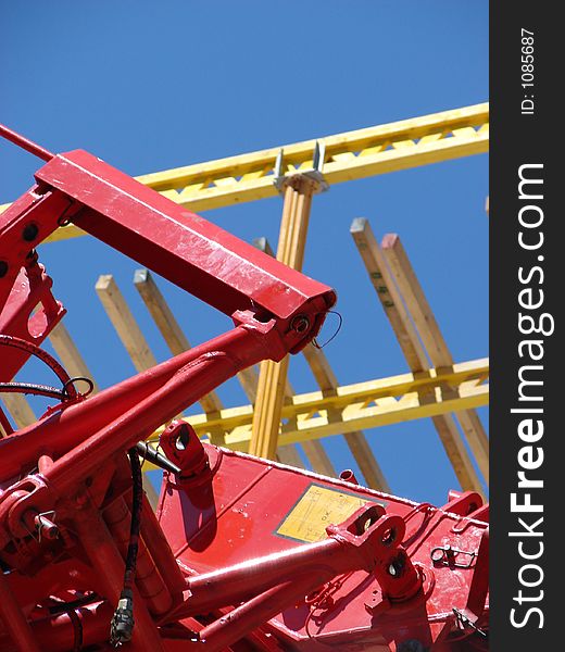 Pieces of construction materials in red and yellow against a blue sky. Abstract. Pieces of construction materials in red and yellow against a blue sky. Abstract.
