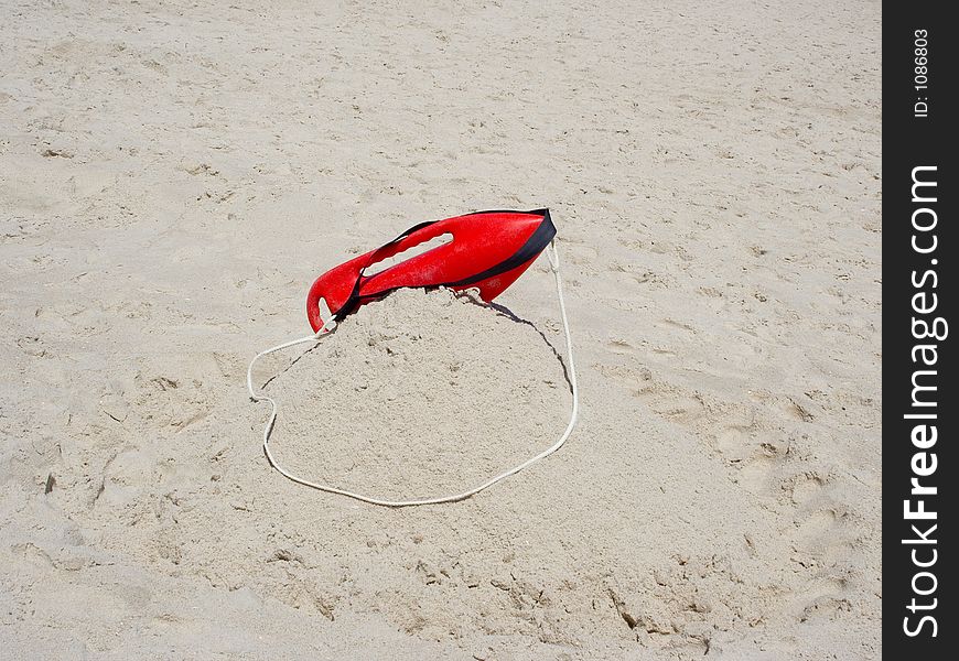 A lifeguard's float sits atop the sand ready in case of an emergency. A lifeguard's float sits atop the sand ready in case of an emergency.
