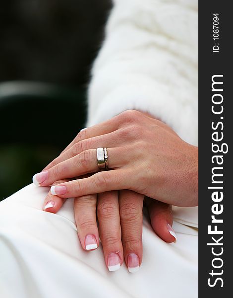 A wedding band on the hand of a new bride, cropped shot of hands and ring.