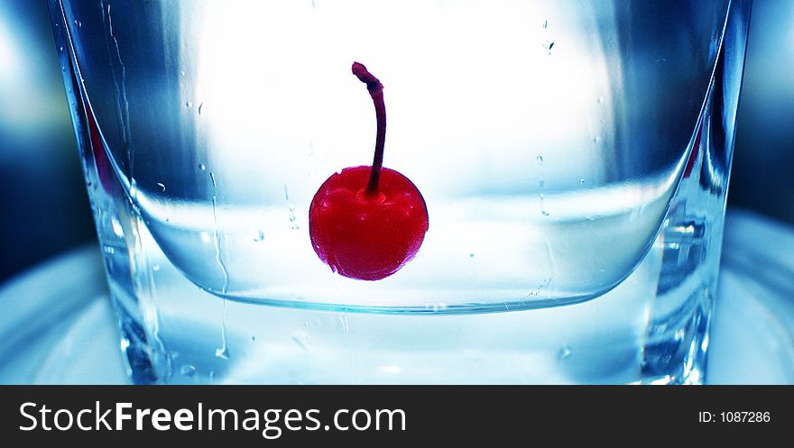 Cool, red cherry floating in clean, pure refreshing water. Cool, red cherry floating in clean, pure refreshing water