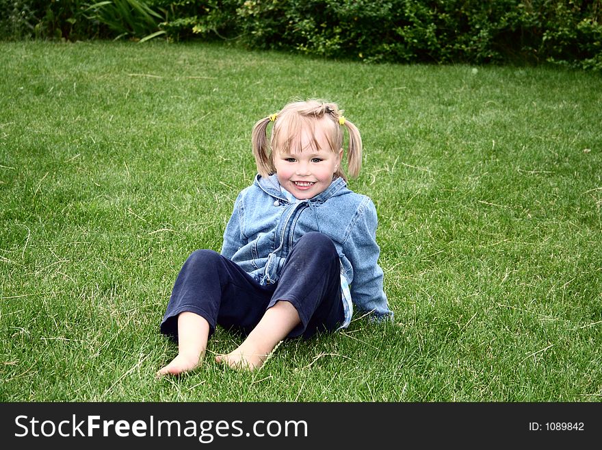A girl sitting on the grass. A girl sitting on the grass