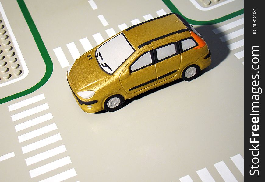 Gold family toy car traveling and passing an empty intersection. Gold family toy car traveling and passing an empty intersection